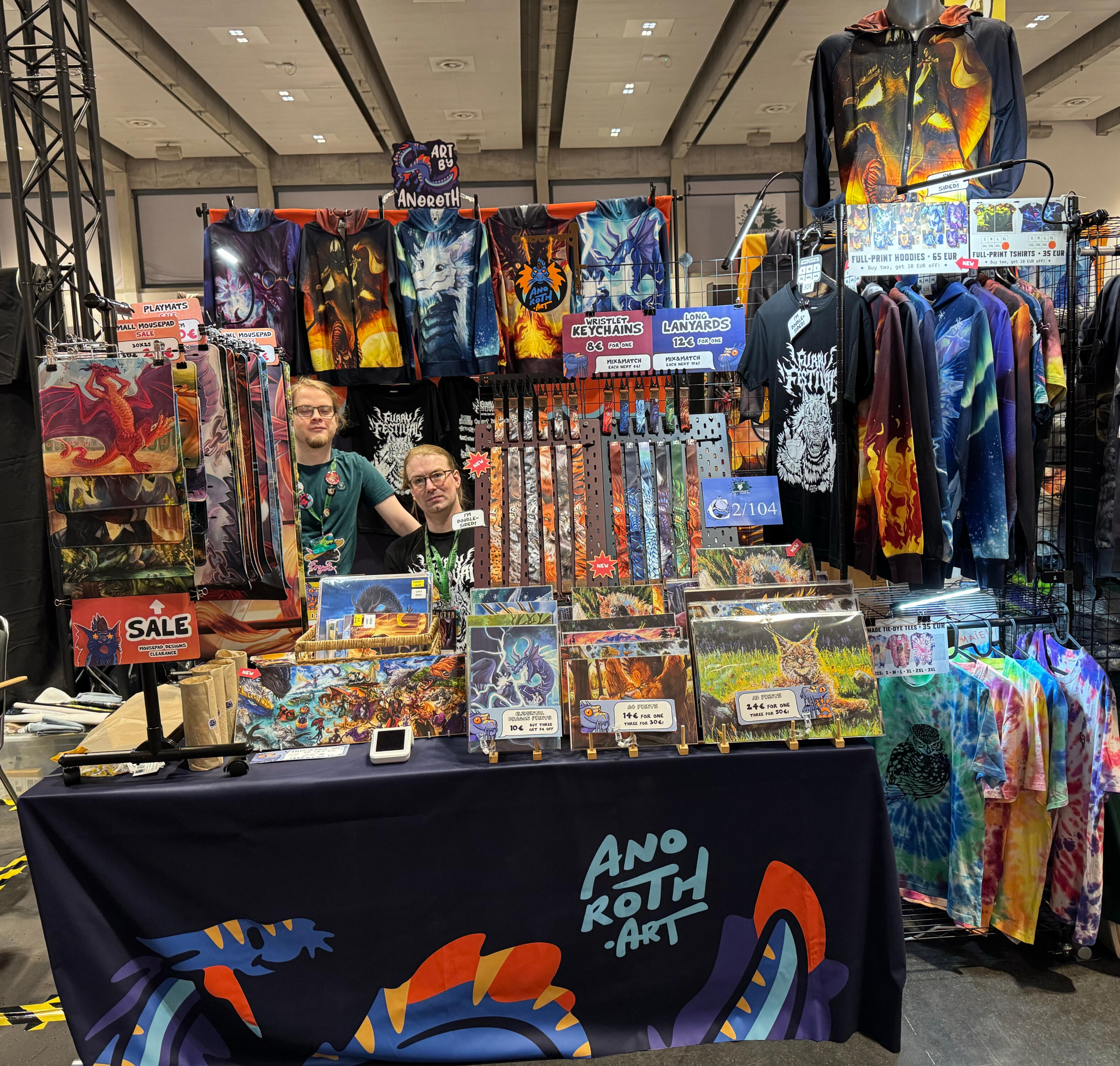 Eurofurence 2026 setup on double table (260cm) wide space, and my two assistants